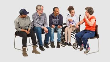 A group of people meeting and sitting on chairs talking