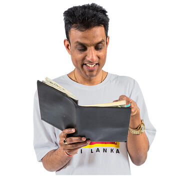 A man smiling and looking in a diary or book.