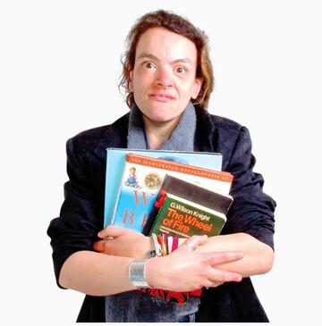 A young woman holding lots of school books in her arms