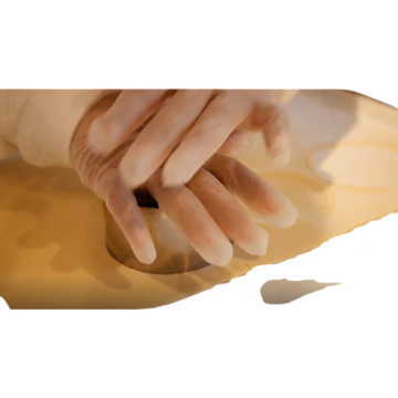 Two hands pressing a round cutter into some pastry.