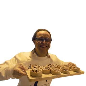 Michael smiling and holding a board with his mince pies on.