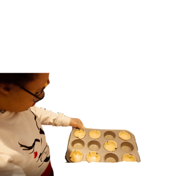 Michael holding a bun tin with some pastry in some of the holes.