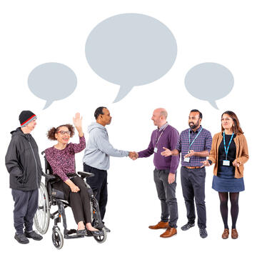 A group of people talking to each other and shaking hands.