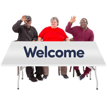 3 people sitting at a table which has the word welcome on it.