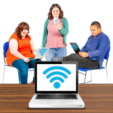 3 people using devices.  In front of them is a laptop with a wifi symbol.