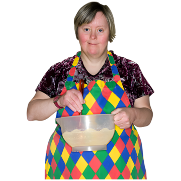 A woman with a colourful apron mixing ingredients in a bowl