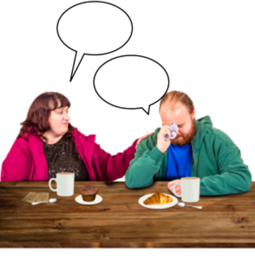 A man and a woman are talking at a table. The woman is comforting the man as he is crying