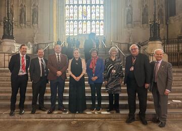 A photograph of the All Party Parliamentary Group taken on steps inside the Houses of Parliament
