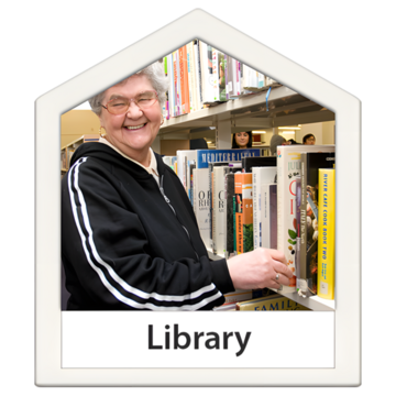 A picture of a woman taking a book off a book shelf which is full of other books