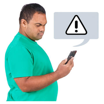 A man looking at his mobile phone which has a triangle with an exclamation mark above it.