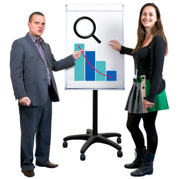 Two people standing beside a flipchart and pointing to the image of a graph and a bar chart on it.