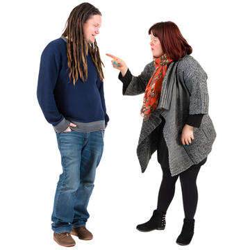 A lady looking at a man and pointing her finger at him.