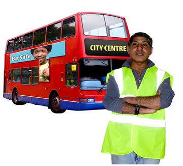 A man in a high vis jacket standing in front of a bus with his arms folded.