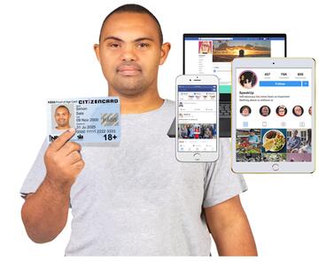 A man holding up a PASS proof of age card and a tablet, laptop and phone with social media on them.