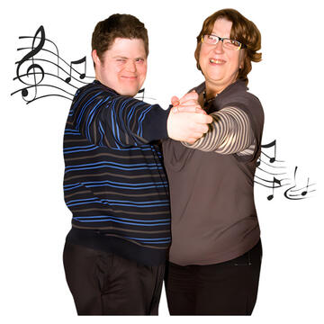 Two people dancing together with music playing behind them.