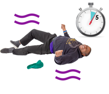A man lying on the floor shaking next to a stop watch showing 5 minutes