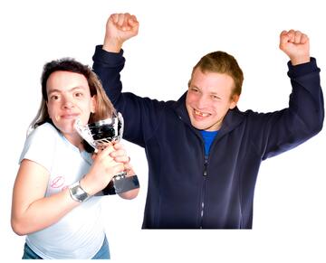 A woman hugging a trophy and a man smiling and raising his arms celebrating.