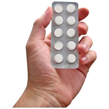 A hand holding a blister pack of tablets.