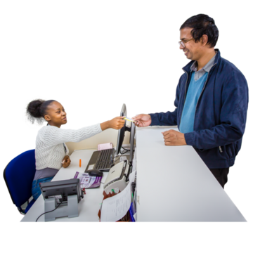 A man giving a letter to a receptionist across a desk