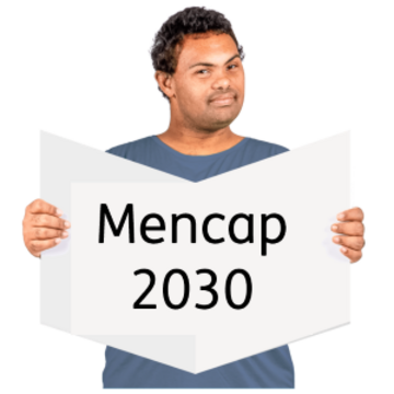 A man reading a book called Mencap 2030