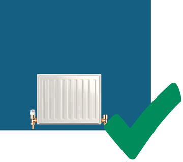 A tick beside a radiator that is front of a blue wall.