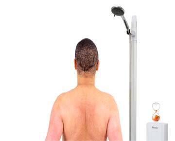 The back of a man standing in a shower and a timer on top of the shower unit.