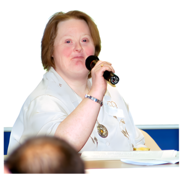 A person sitting at a table with a microphone
