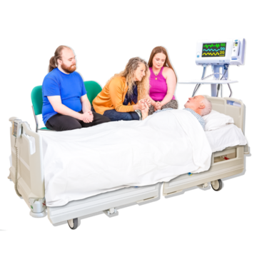 Three people sitting with someone in a hospital bed