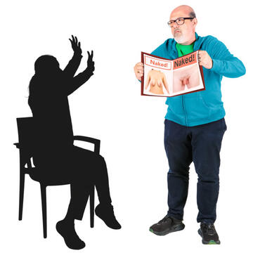 A man holding a magazine open with pictures of naked bodies in it.  He is showing the magazine to someone who has their hands up as if to say stop.