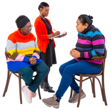 A woman writing something down whilst standing over a couple talking on chairs