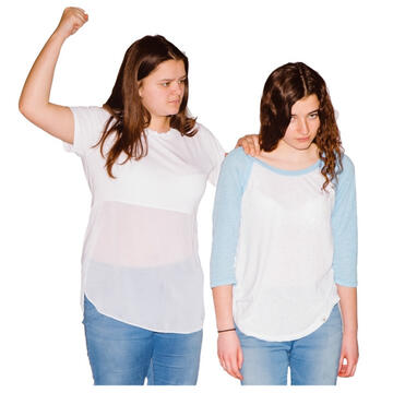 A woman holding her arm up as if she is going to hit the woman she is holding on to.