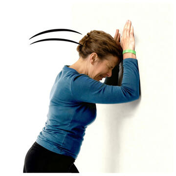 A woman banging her head against a wall.