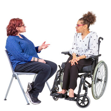 Two women sitting facing each other.  One woman is talking, the other one is listening.