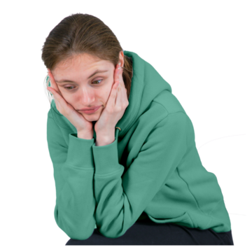 A young woman sitting with her elbows on her knees and her head in her hands looking worried.