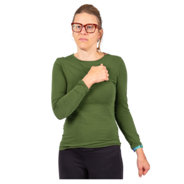 A woman signing 'sorry' in Makaton by making a fist with her hand and rubbing it in a circle on the top left of her chest.