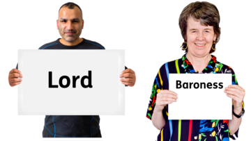 A man holding a board in front of him which says Lord and a woman holding a board in front of herself which says Baroness.