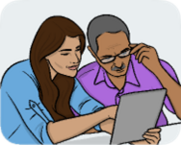 A man and a woman sitting together looking at the screen of a tablet.
