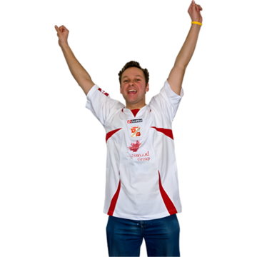 A man in a football shirt with his arms in the air.