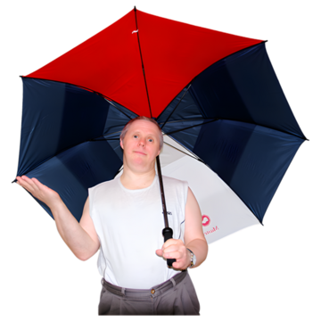 A man in a vest top using a large umbrella to keep in the shade on a hot day