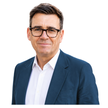 Andy Burnham, wearing a blue suit and white shirt.