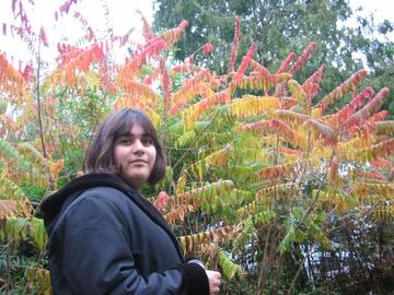 Tara standing in front of trees and bushes