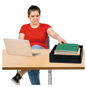 A woman infront of a laptop putting books in a filing tray on her desk