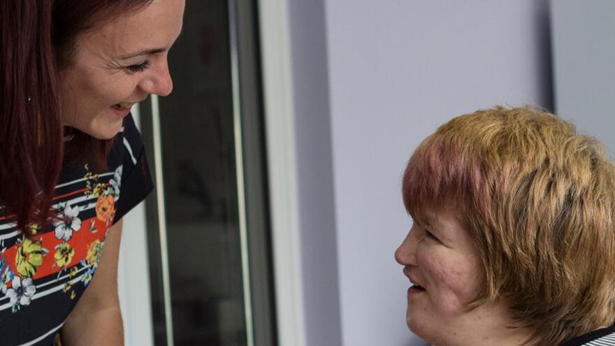 Two people smiling and looking at each other.