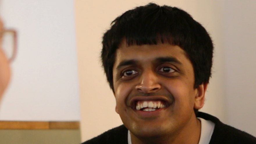 Young man with dark hair, smiling.