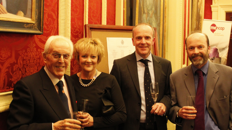 Group of four people stood in parliamentary building posing for camera.