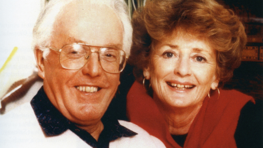 Photo of Brian Rix smiling and posing for photograph with woman next to him.