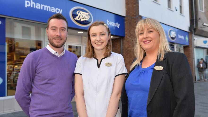 Three employees stood in front of Boots store
