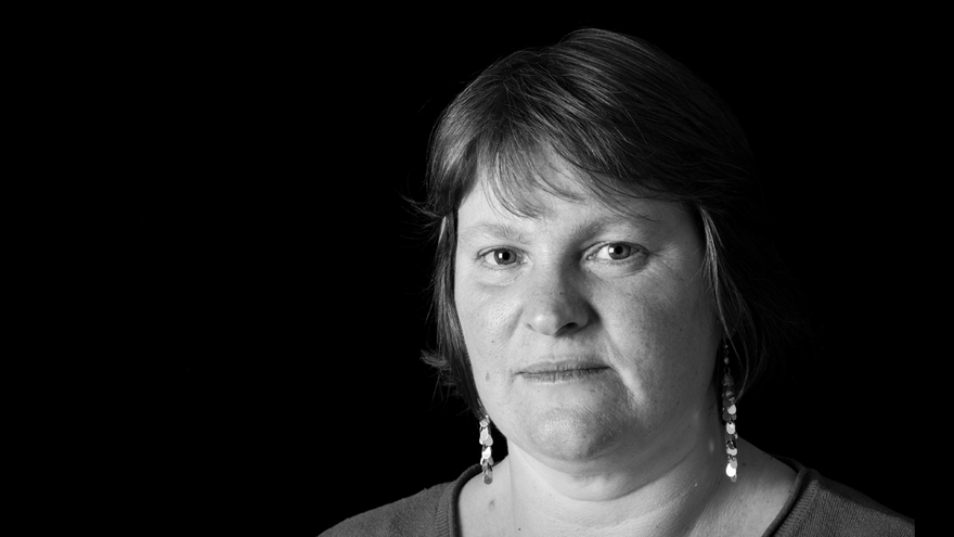 Woman with short hair and earrings looking into camera.