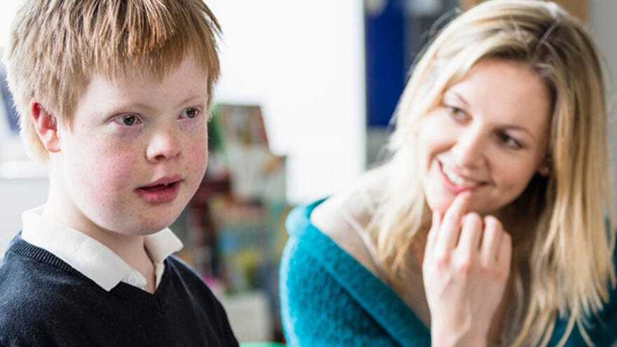 Schoolboy sat in classroom with female teacher