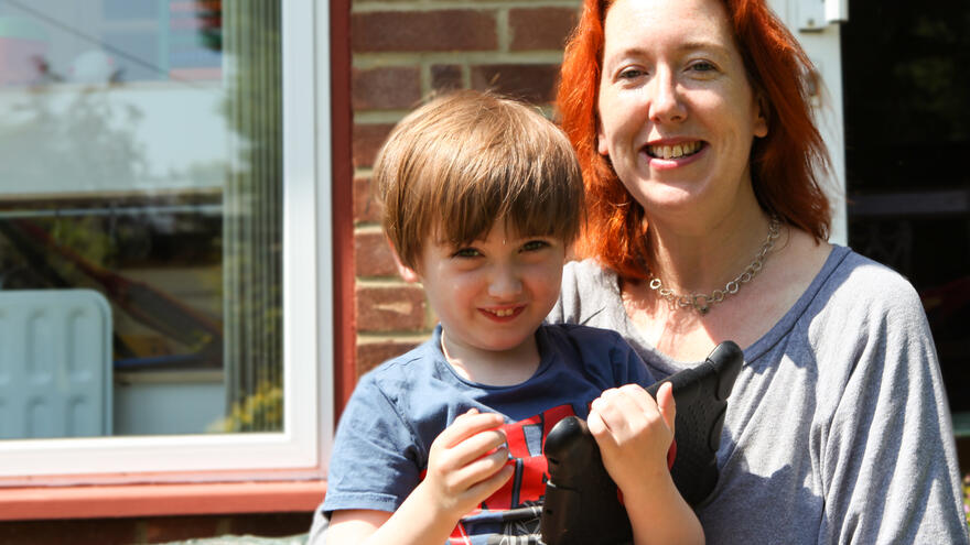 Mother sat outside with young son on her lap.